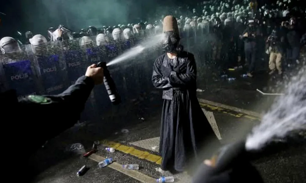The police spray a man dressed as a whirling dervish in a gas mask during the pro-İmamoğlu protest in Istanbul (Source: X platform)