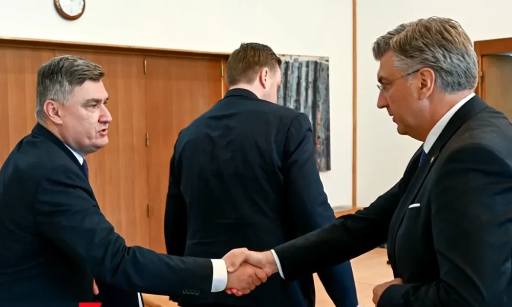 Kezet fogott a horvát elnök (balról) és a horvát miniszterelnök (jobbról). A Horvát Védelmi Tanács üléséről - amelyen találkoztak - televíziós felvétel nem készült