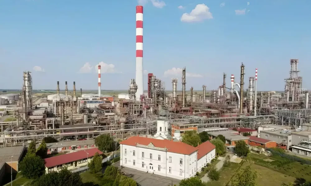 Finomító és kolostor egy kupacban, a Vojlovica kolostor Pancsován, háttérben a finomítóval