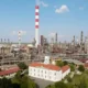 Finomító és kolostor egy kupacban, a Vojlovica kolostor Pancsován, háttérben a finomítóval