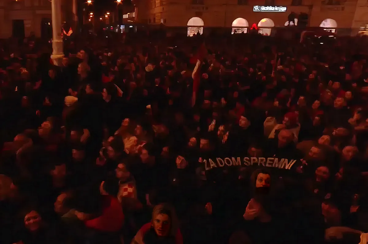 A "Za dom spremni" felirat egy sálon volt látható a tömegben, de volt HOS-zászló is. A HOS a nacionalista Horvát Jogpárthoz kötődő önkéntes, félkatonai alakulat volt 1991 és 1993 között. Tagjai között voltak horvát nacionalisták, külföldi önkéntesek, valamint szélsőjobboldali szimpatizánsok is. 1993-ban a horvát állam beolvasztotta őket a reguláris hadseregbe, mert túl önállóak és politikailag kényelmetlenek voltak. (Forrás: Screenshot, HRT2)