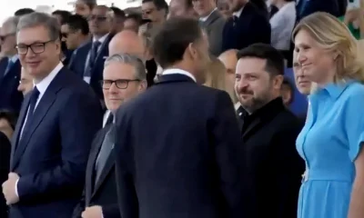 Aleksandar Vučić a diadalív árnyékában felállított állami VIP lelátó első sorában, Volodimir Zelenszkij ukrán elnökkel fogja közre a brit miniszterelnököt