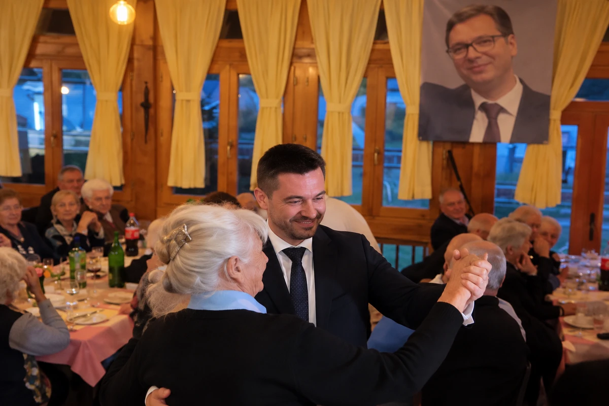 Iratmegsemmisítés: már a hatalomváltás előtt túlóráznak a papírdarálók 2 Relja Ognjenović nyugdíjasokat "táncoltat meg" egy szavazatszerző akció során, a háttérben a főnök képe (Forrás: X platform)